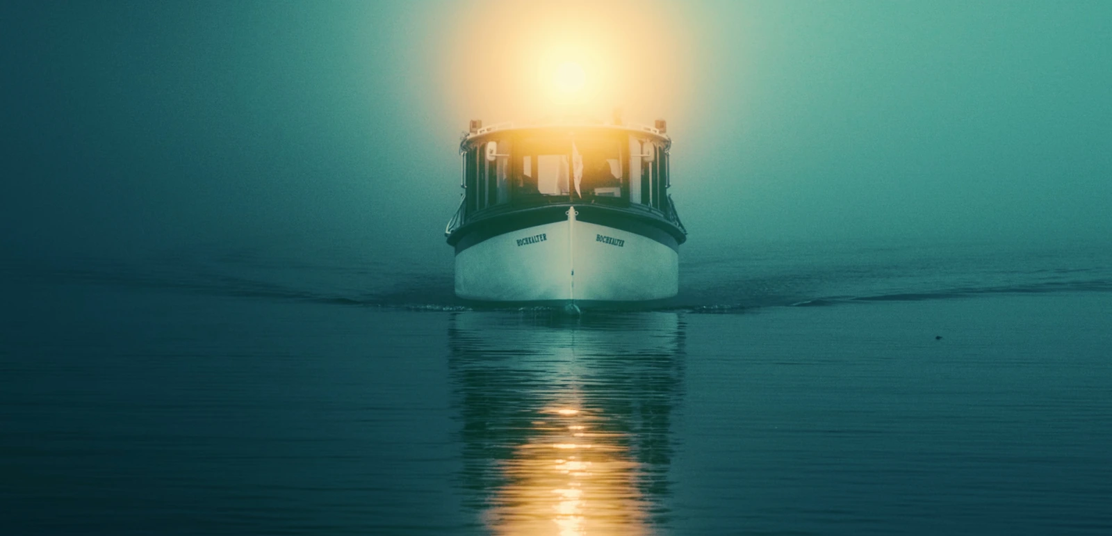 Boot mit Licht im Nebel über dem Wasser