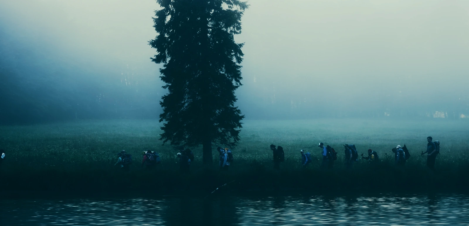 Wandergruppe im Nebel neben einer Baumsilhouette